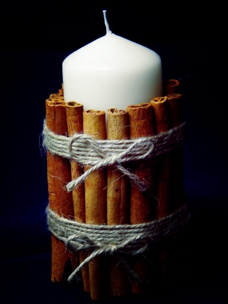 decorating candles with cinnamon sticks